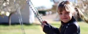 young child on swing in park in Anna, TX