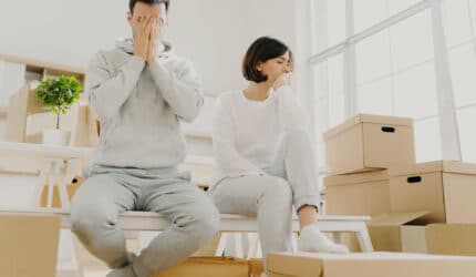 worried couple have closing stress surrounded by moving boxes