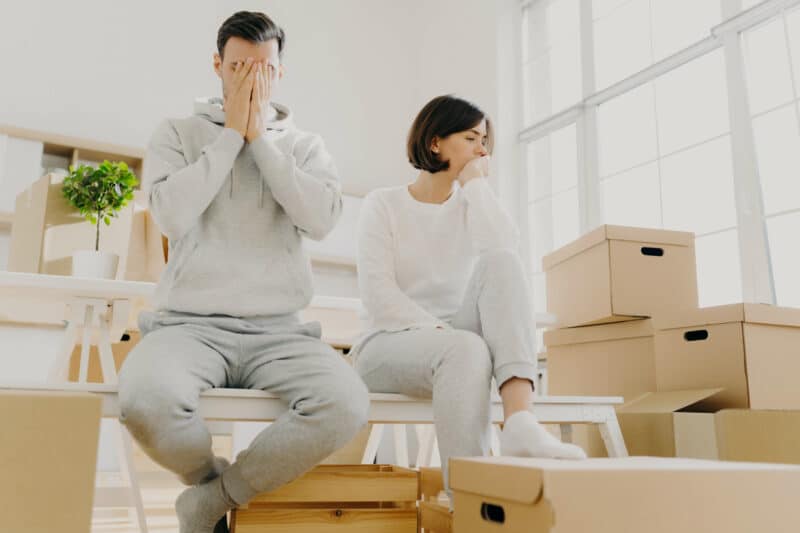 worried couple have closing stress surrounded by moving boxes