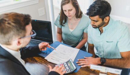 young couple talking to a lender about financing a home loan